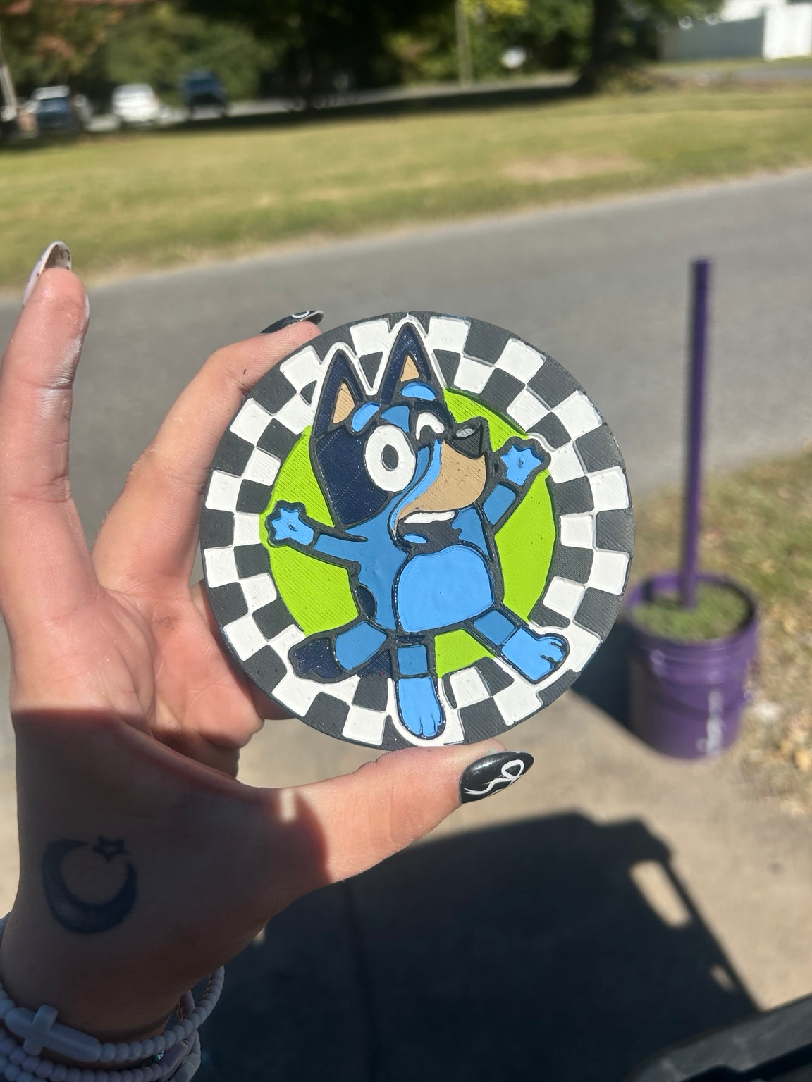 Hand-painted Bluey freshie on bright green background with a black and white checkerboard border
