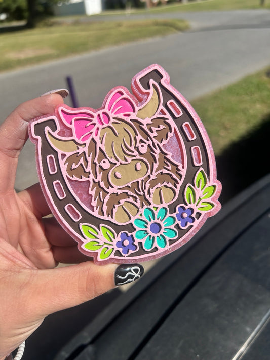 Highland cow in a horseshoe with a pink bow and floral details, hand-painted car freshie in brown, turquoise, green and pink