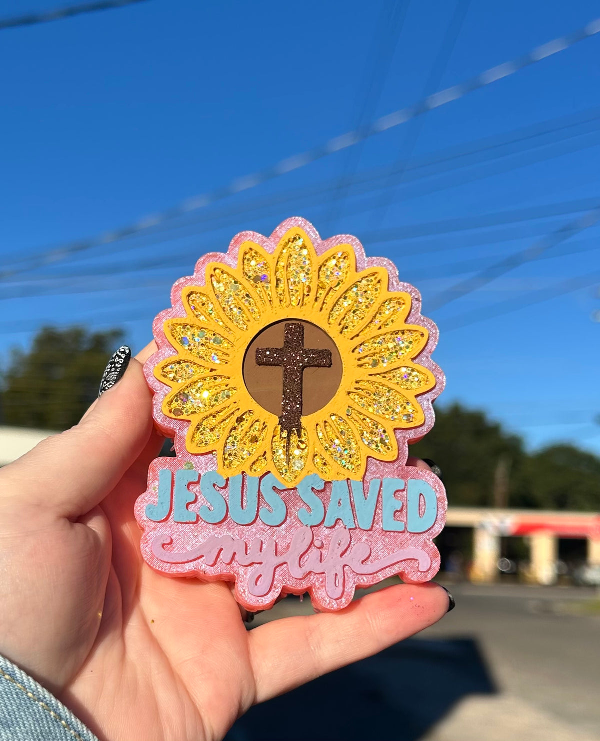 Hand-painted Jesus Saved My Life sunflower freshie with cross in center, yellow glitter petals and pink background