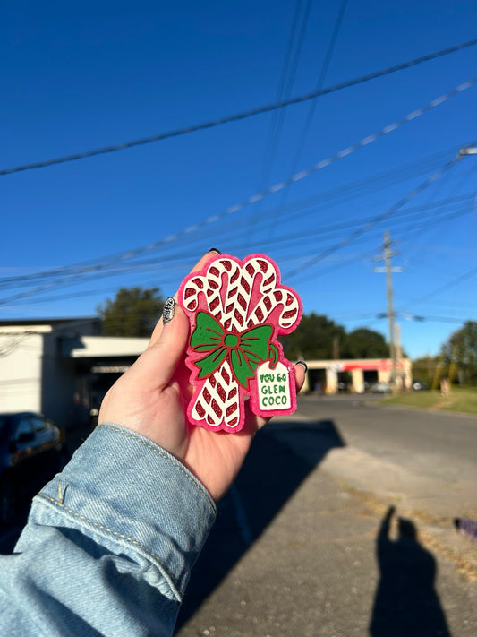 Candy cane freshie with bow and tag reading You Go Glen Coco, shown in pink, green, red and white